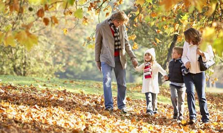 Family walk through park in autumn